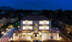a large white building at night with lights at Residence Deamarina in Marina di Massa