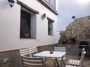 a white table and chairs on a patio at Tío Genaro in Cumbres de San Bartolomé