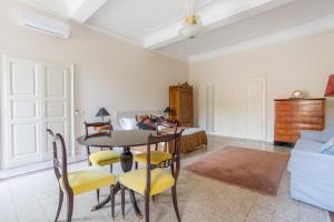 un soggiorno con tavolo, sedie e letto di PALAZZO SABBIONI SUITE DEL CONTE Elegant Suite In Old Monastery City Center a Ferrara