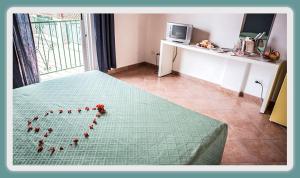 a room with a bed with roses in the shape of a heart at VRclub - Villa Ridente Residence in Gioiosa Marea