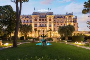 um grande edifício com um parque em frente em Grand Hotel Rimini em Rimini