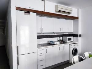 eine weiße Küche mit weißen Schränken und einem Kühlschrank in der Unterkunft Flats Friends Tetuan in Valencia
