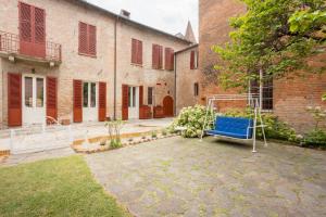 a blue bench in the courtyard of a building at PALAZZO SABBIONI SUITE DEL CONTE Elegant Suite In Old Monastery City Center in Ferrara