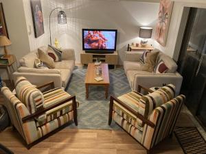 a living room with three couches and a tv at 1166 on Booner - Hawks Nest in Hawks Nest