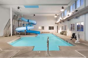 a swimming pool with a slide in a building at Days Inn by Wyndham West Yellowstone in West Yellowstone