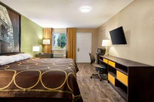 a hotel room with a bed and a desk at Super 8 by Wyndham Brookhaven in Brookhaven