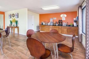 Super 8 by Wyndham Brookhaven في بروكهافن: غرفة طعام مع طاولة وكراسي ومكتب
