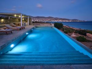 an infinity pool with stairs leading to a house at Luxury Villa Seafront in Aliki
