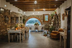 un restaurante con mesas y sillas y una pared de piedra en Agriturismo Molino dei Frati en Trescore Balneario