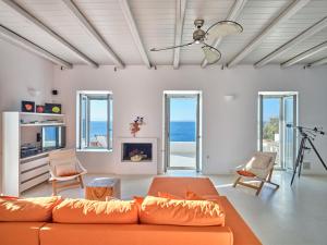 a living room with an orange couch and chairs at Luxury Villa Seafront in Aliki