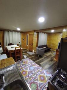 a living room with a kitchen and a dining room at Cabaña Volcán Hornopirén in Hornopiren