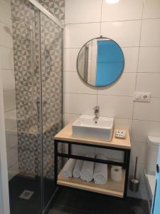 a bathroom with a sink and a glass shower at Alojamientos Central in Porriño