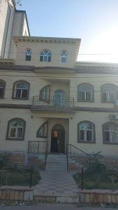ein großes Gebäude mit einer Treppe, die zu einer Tür führt in der Unterkunft GUESTO HOSTEL in Taschkent