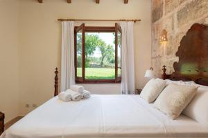Schlafzimmer mit einem großen weißen Bett und einem Fenster in der Unterkunft Alcudiola in Santa Margalida