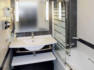 
a bathroom with a sink and a mirror at Novotel Bordeaux Centre Gare Saint Jean in Bordeaux
