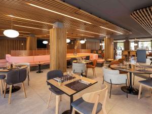 ein Restaurant mit Tischen und Stühlen und eine Bar in der Unterkunft Novotel Bordeaux Centre Gare Saint Jean in Bordeaux
