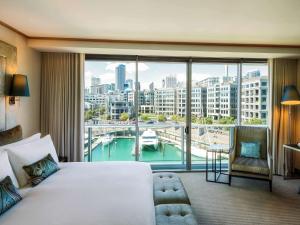 a hotel room with a large window overlooking the ocean at Sofitel Auckland Viaduct Harbour in Auckland