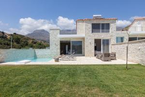 una casa de piedra con un patio con piscina en Mythos villas en Damnoni