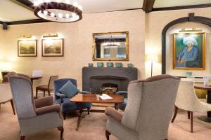 a living room with a fireplace and chairs and a table at Best Western Red Lion Hotel in Salisbury