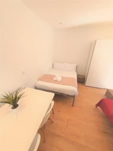 a small room with a bed and a table at Turay Court Holiday Apartments in Bournemouth