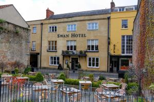 een hotel met tafels en stoelen ervoor bij The Swan Hotel, Wells, Somerset in Wells