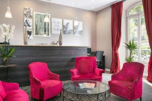 a waiting room with red chairs and a table at Best Western Hotel Lakmi Nice in Nice