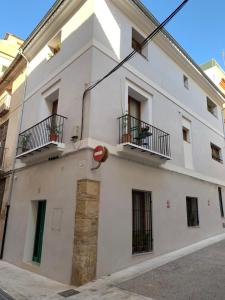 a white building with two balconies on a street at LA MOMA Apartments & Room in Xàtiva
