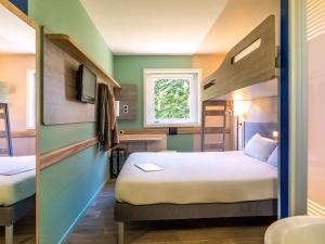 Postel nebo postele na pokoji v ubytování Ibis Budget Lyon Est Saint Quentin Fallavier