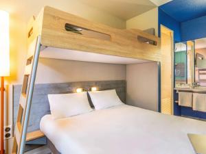 Postel nebo postele na pokoji v ubytování Ibis Budget Lyon Est Saint Quentin Fallavier
