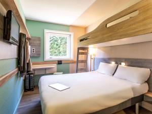 Postel nebo postele na pokoji v ubytování Ibis Budget Lyon Est Saint Quentin Fallavier