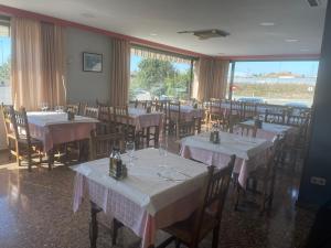 un restaurante con mesas y sillas con manteles blancos en Hotel Reina Isabel, en Lleida