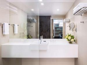 a bathroom with a sink, mirror, and bathtub at Novotel Geelong in Geelong