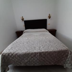 um quarto com uma cama com um edredão cinzento em Hotel Conde em Taboadela