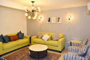 una sala de estar con 2 sofás amarillos y una mesa. en Amwaj Resort For Families Only, en Al Khobar