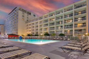 a hotel with a swimming pool in front of a building at Quality Inn Boardwalk in Ocean City