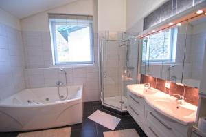 a bathroom with a tub and a shower and a sink and a bath tub at Penthouse Bruckberg by Four Seasons Apartments in Zell am See