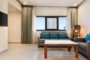 a living room with a couch and a table at Wyndham Garden Ajman Corniche in Ajman 