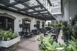 een patio met tafels, stoelen en planten bij Radisson Collection Hotel, Old Mill Belgrade in Belgrado