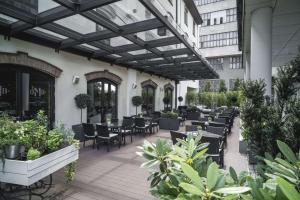 an outdoor patio with tables and chairs and plants at Radisson Collection Hotel, Old Mill Belgrade in Belgrade