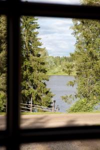 vista para um lago visto através de uma janela em Maatilamatkailu Ali-Ketola em Kokemäki