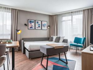 une chambre d'hôtel avec un lit et un canapé dans l'établissement Aparthotel Adagio Paris Suresnes Longchamp, à Suresnes