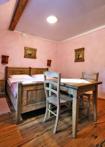 a bedroom with a bed and a wooden table and chairs at Pomona Relaxing Nature Guest House in Rogaška Slatina