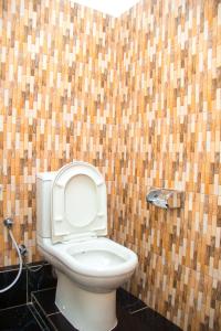 La salle de bains est pourvue de toilettes et d'un mur carrelé. dans l'établissement MINA CHAI HOUSE BNB, à Arusha
