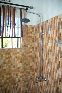 um chuveiro na casa de banho com uma cortina de chuveiro em MINA CHAI HOUSE BNB em Arusha