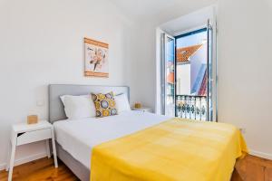 ein weißes Schlafzimmer mit einem Bett und einem Balkon in der Unterkunft Olarias Terrace Lisbon in Lissabon
