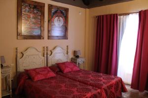 a bedroom with a bed with red sheets and a window at Hotel Rural Los Jarales in Istán