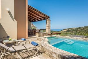 uma villa com uma piscina e mobiliário de pátio em Margarita's Villas em Chania Town