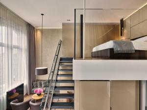 a living room with a staircase leading to a stairwell at Conservatorium Hotel in Amsterdam