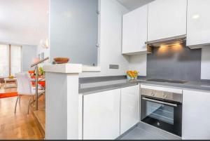 a kitchen with white cabinets and a stove top oven at Homely Málaga Luxury Sebastian Souviron in Málaga