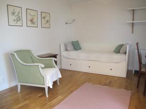 a bedroom with a bed and two chairs and a rug at Dahmskahuset in Kalmar